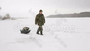 一位老人在冬天进入一个冰冻的湖，把东西放在雪橇上。 穿着<strong>土</strong>黄色暖衣的男人